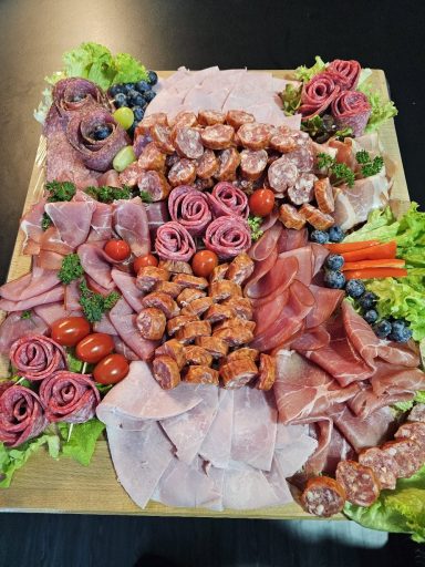 Bunte Platte mit Wurst, Käse, Trauben, Gemüse und frischem Salat.