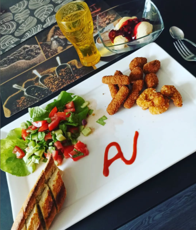Bunt angerichteter Teller mit Salat, frittierten Snacks und einem Dessert mit Eis.