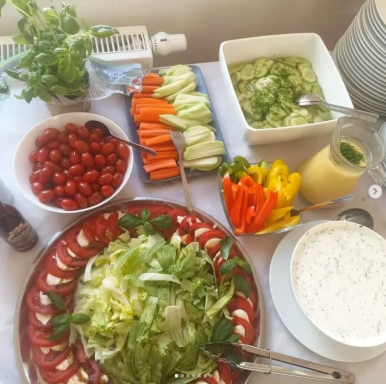 Bunte Gemüsesorten, Tomaten, Salat und Dips auf einem Tisch angerichtet.